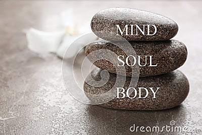 Stones with words MIND, BODY, SOUL on brown marble background, space for text. Zen lifestyle Stock Photo