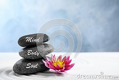 Stones with words Mind, Body, Soul and lotus flower on sand. Zen garden Stock Photo