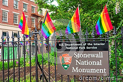 Stonewall National Monument sign on the fence decorated with rainbow flags at Christopher Park Editorial Stock Photo