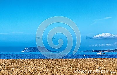 A stony beach looking out to an island Stock Photo