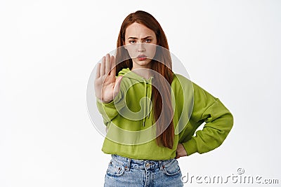 Stop. Angry ginger girl stretch hand to prohibit, reject and disapprove, decline something, say no, forbid action Stock Photo