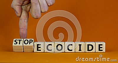 Stop ecocide symbol. Businessman turns wooden cubes and changes words ecocide to stop ecocide. Beautiful orange background, copy Stock Photo