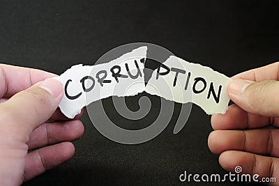 Stop and fight corruption concept. Human hand tearing a piece paper with written word corruption. Stock Photo