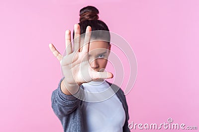 Stop! Portrait of angry teenage girl showing prohibition ban block gesture with palm, negative expression. studio shot, pink Stock Photo