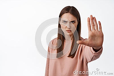 Stop it. Serious and determined woman extend palm and say no, forbid and disagree, condemn smth bad, forbid and reject Stock Photo