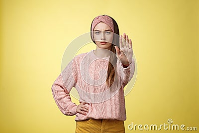 Stop it. Serious-looking confident focused young cute girl extending arm hold, tresspass gesture, frowning displeased Stock Photo