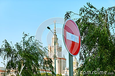 Stop sign on background of blue sky and silhouette of famous university in Moscow Stock Photo