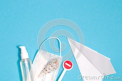 stop sign, cockleshell, alcohol hand antiseptic, protective mask and paper plane on blue background of opium spots top view, quara Stock Photo