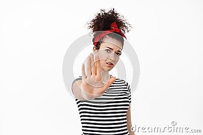 Stop it. Young brunette woman stretch hand and tell no, forbid something, blocking you, keep away social distancing Stock Photo