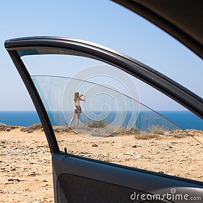 Stopover. Woman taking photo from seashore Stock Photo