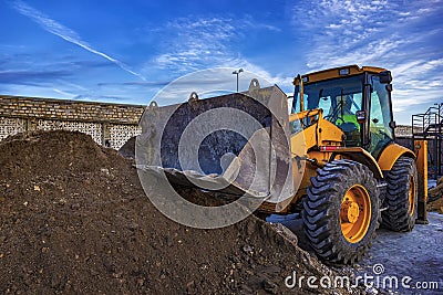 Stopped yellow excavator with shovel at construction site Stock Photo