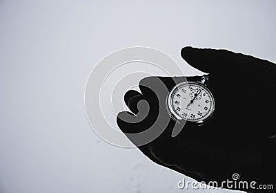 A stopwatch in hand. Black gloves on a white background. Ancient stopwatch Stock Photo