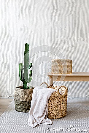 Storage box, wicker basket with plaid and cactus near wooden table Stock Photo