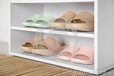 Storage cabinet with different pairs of rubber slippers indoors Stock Photo