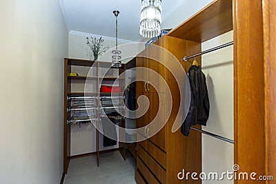 Storage room with shelves on which things lie, hangers with clothes. Pantry. Storage room in the cottage Stock Photo