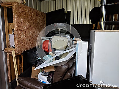 A self storage unit full of stored household junk items Stock Photo