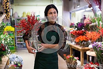 Store employee makes Christmas arrangement with flowers Stock Photo