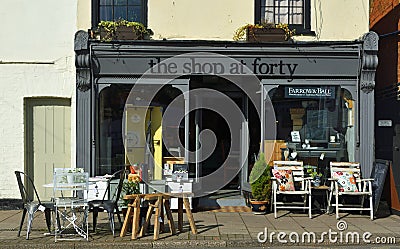 Store front of The Shop at Forty which sells Retro and Vintage wares with chairs and tables outside on the pavement. Editorial Stock Photo