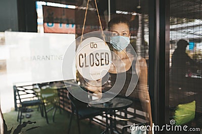 Store Owner in medical mask closed restaurant for quarantine Stock Photo