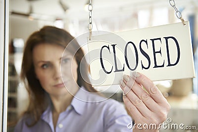 Store Owner Turning Closed Sign In Shop Doorway Stock Photo