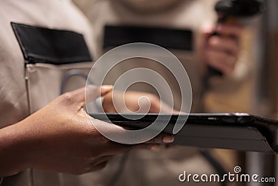 Storehouse employees hands using digital tablet in stockroom, Stock Photo