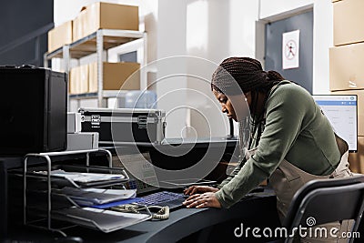 Storehouse manager analyzing goods logistics on laptop Stock Photo