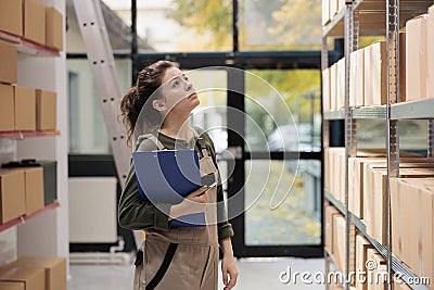 Storehouse manager looking at shelves full with boxes Stock Photo