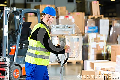 Storeman with mover at warehouse of forwarding Stock Photo