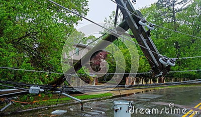 The storm caused severe damage to electric poles falling tilt. Stock Photo