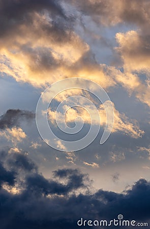 Storm clouds in the blue sky. Spring thunderstorm. The last sun`s rays at sunset. Calm before the storm Stock Photo