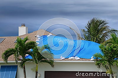 Storm damaged house with protective tarp Stock Photo