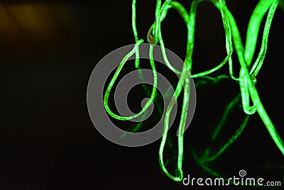 Toxic green lime lighting with a specific pattern. Woven filaments, cable, wires with outgoing light. Neon electroluminescent wire Stock Photo