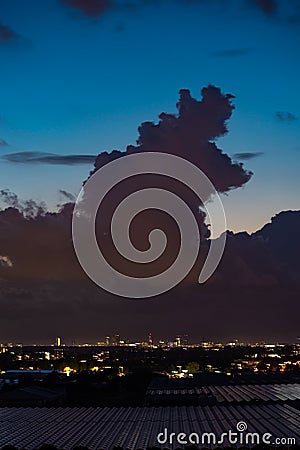 Silhouette of a tall storm cloud over a city Stock Photo