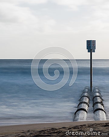 Stormwater pipes at Manly Beach with smooth long exposure waves Stock Photo