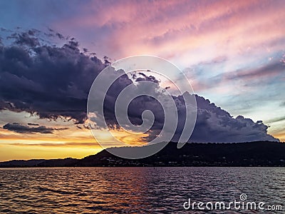 Stormy dark cumulonimbus cloud in a bright sunset sky Stock Photo