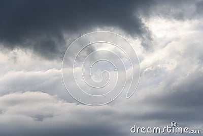Stormy gray skies with some clouds highlighted white by the sun, as a nature background Stock Photo
