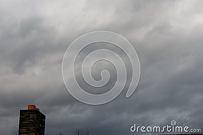A Stormy Gray Sky With a Chimney Stock Photo