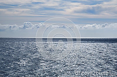 Stormy grey sea, calm before the storm, blue sky with some white Stock Photo