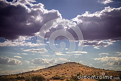 Stormy sky and promising rain clouds over a dry Kalahari desert hill Stock Photo