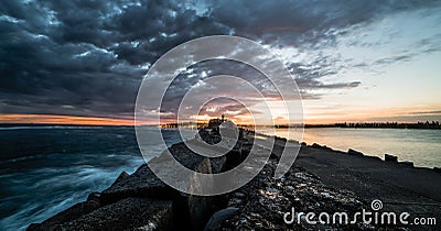 Stormy skys building over the Newcastle brake wall - Australia Stock Photo