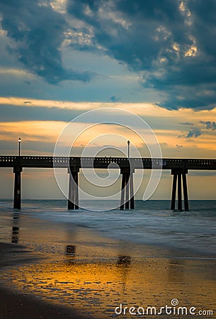 Stormy thunderclouds hover over the sunrise at Wrightsville Beach Stock Photo