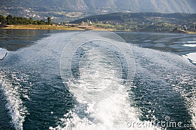 Stormy trace of motor boat crossing the emerald waters. Stock Photo