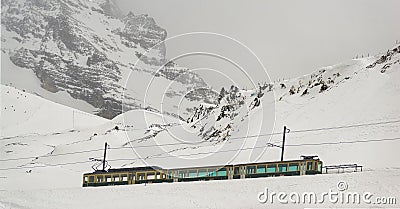 Train in Kleine Scheidegg under Eiger, Monch and Jungfrau peaks in Swiss Alps, Berner Oberland, Grindelwald, Editorial Stock Photo