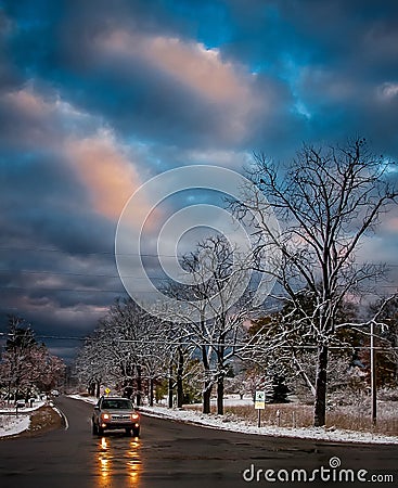 Stormy Winter Morning with Car lights reflecting off wet roads Stock Photo