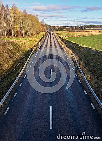 straight highroad with wet and dry tarmac Stock Photo