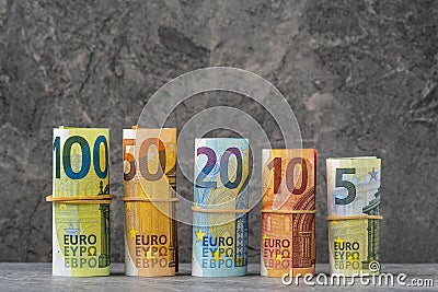 Straight row of accurately rolled hundred, fifty, twenty, ten and five paper euro banknotes Stock Photo