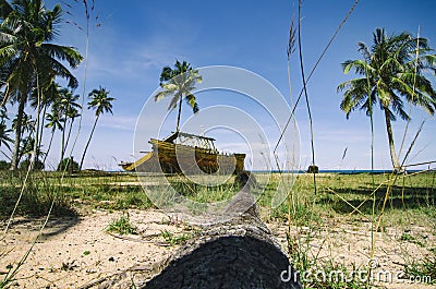 Shipwrecked on the sandy beach over cloudy sky background at sunny day Stock Photo