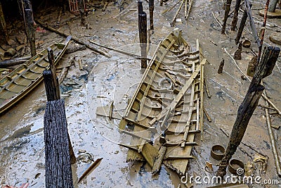 Stranded wreck of the little wooden boat with pieces of wood all around after storm Stock Photo