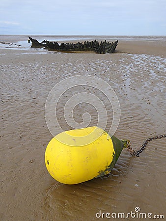 Stranded wreck and yellow buoy Stock Photo