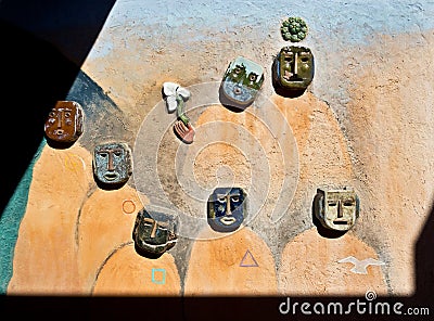 Strange artwork on a wall, ceramic faces Stock Photo